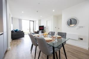a dining room with a glass table and chairs at Flat close to Manchester Picadilly station in Manchester