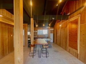 a room with a table and some wooden walls at 赤瓦の一軒家で伝統とモダンを満喫。ベッド6台、市内観光スポット車で15分以内。12時チェックアウト in Yamazatu +25 photos