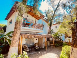 a house with a balcony with a table and chairs at VOVO TELO LODGE in Toliara