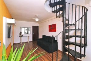 un salon avec un escalier en colimaçon noir dans l'établissement Cobertura duplex 2 quartos com terraço e piscina, à Rio de Janeiro