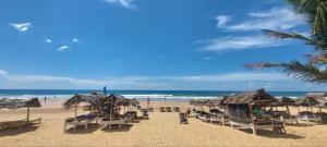 a beach with chairs and umbrellas and the ocean at Hotel Universal Beach in Hikkaduwa