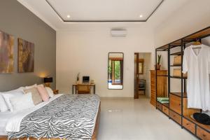een slaapkamer met een groot bed en een spiegel bij Villa Royal Canggu - 3 minutes to FINNS Beach club! in Canggu