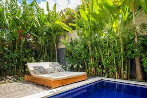 een bed op een terras naast een zwembad bij Villa Royal Canggu - 3 minutes to FINNS Beach club! in Canggu
