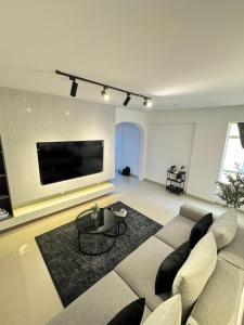 uma sala de estar com um sofá e uma televisão em Marhaba Retreats em Mascate