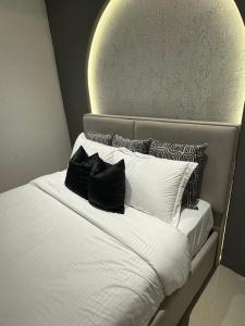 uma cama com duas almofadas pretas em cima em Marhaba Retreats em Mascate