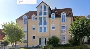a large apartment building with trees in front of it at Schöne Gartenwohnung im Seenland in Wackersdorf