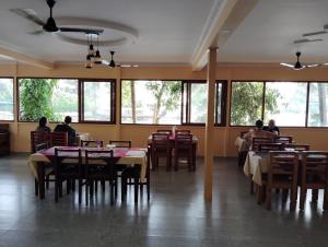 un grupo de personas sentadas en mesas en un restaurante en The Lake Paradise Boutique Resort en Alleppey