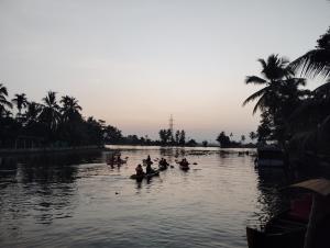 a group of people are rowing in a river at The Lake Paradise Boutique Resort in Alleppey