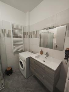 een badkamer met een wasmachine en een wastafel bij appartamento C&Y Ghiberti in Novara