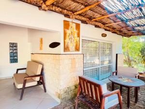 a living room with a fireplace and a table and chairs at VOVO TELO LODGE in Toliara
