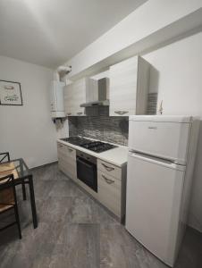 una cucina con piano cottura e frigorifero bianco di appartamento C&Y Ghiberti a Novara