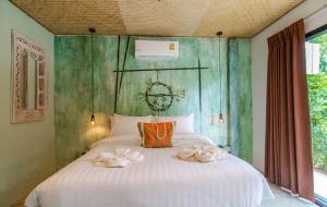 a bedroom with a bed with towels on it at Dreamcatcher Boutique Hotel in Bophut