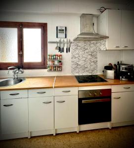 une cuisine avec un évier et une cuisinière four supérieur dans l'établissement Habitación en la playa, à Valence
