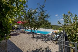 a swimming pool with a tree and a fence at Newly refreshed property JOVI-relaxing, fenced, private, heated pool & view in Tugare