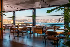 a restaurant with tables and chairs and a view of the water at Ring Stone Hotels Bosphorus - Special Class in Istanbul