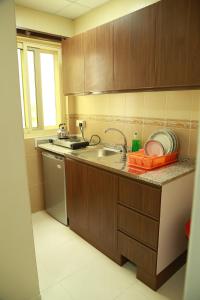a kitchen with a sink and a dishwasher at Miami Hotel Apartment in Sharjah