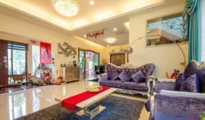 ein Wohnzimmer mit lila Sofas und einem Tisch in der Unterkunft White Palace B&B in Jian