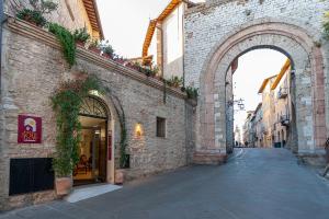 un vicolo con arco in un edificio di mattoni di Hotel Sole ad Assisi