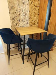 a wooden table and two blue chairs in a room at apartments with separate kitchen by the sea in Ashdod