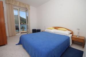 a bedroom with a blue bed and a balcony at Apartments by the sea Slano, Dubrovnik - 8538 in Slano