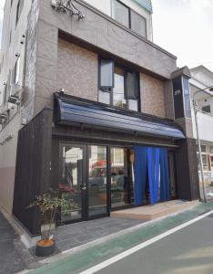 un edificio con una tienda con cortinas azules en 4S STAY Awaikeda ikedaonsenyoko, en Miyoshi