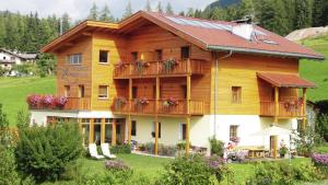 una grande casa in legno con balconi e fiori di Residence Zirmer Wohnung Wasser a Castelrotto