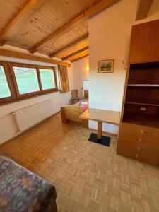 a bedroom with a bed and a desk in a room at Residence Zirmer Wohnung Luft in Castelrotto
