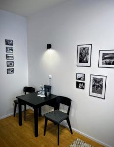 ein Esszimmer mit einem schwarzen Tisch und 2 Stühlen in der Unterkunft Home Heart of the center of Brno - Koliště Passage in Brünn