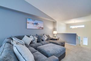 a living room with a large couch and a tv at Charming Retreat With Modern Comforts in West Fargo