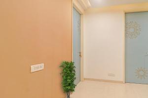 a hallway with a plant next to a door at OYO Flagship Ekasila Suites in Hyderabad