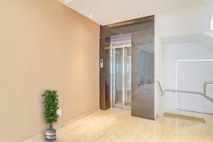 a hallway with a glass door and a potted plant at OYO Flagship Ekasila Suites in Hyderabad