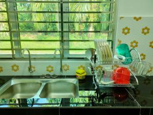 um balcão de cozinha com um lavatório e uma janela em Homestay Fayyadh Teluk Intan 3Room2Bath em Teluk Intan