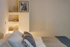 a bedroom with white walls and a bed with pillows at Studio Krinon - Paleo Psychiko in Athens