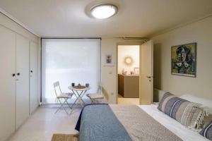 1 dormitorio con 1 cama y 1 mesa con sillas en Studio Krinon - Paleo Psychiko en Atenas