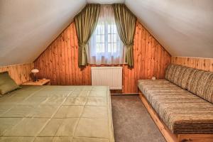 ein Schlafzimmer mit einem Sofa und einem Fenster in der Unterkunft Drevenica v Hybe in Hyby