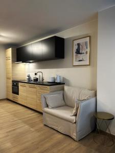 een woonkamer met een bank en een keuken bij Suite luxueuse aux Guillemins in Luik