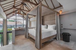 a bedroom with a canopy bed in a room at Loft My Seseh by BaliSuperHost in Canggu