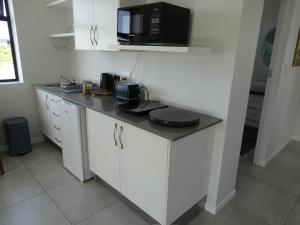 a kitchen with a counter top with a microwave at 14 at Karee in Stilbaai +11 photos