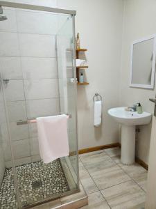 La salle de bains est pourvue d'une douche et d'un lavabo. dans l'établissement Mijn Kitchen Coffee Shop and B&B, à Blantyre