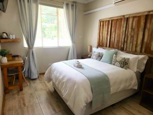 a bedroom with a large bed and a window at Mijn Kitchen Coffee Shop and B&B in Blantyre