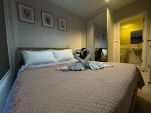 um quarto com uma cama com dois cisnes em Plum central westgate@Bangyai em Ban Bang Krabu