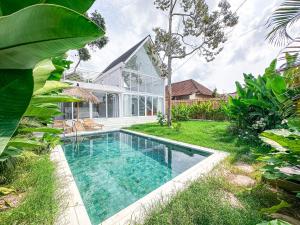 an image of a swimming pool in front of a house at White Villa Ubud in Ubud