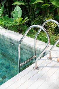 a metal handrail next to a swimming pool at White Villa Ubud in Ubud