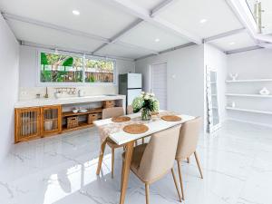 a kitchen with a table and chairs and a sink at White Villa Ubud in Ubud