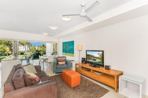 a living room with a couch and a tv at Beachside Apartment 13 in Nelly Bay