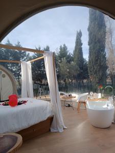 1 dormitorio con cama, bañera y mesa en BUBBLE ROOM PUGLIA Villa Bautier Bubblenights, en Cerignola