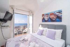 een slaapkamer met een bed en uitzicht op de oceaan bij Apartments Isabora in Dubrovnik