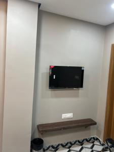 una TV a schermo piatto a parete in camera di TIC ROOMS a Siliguri