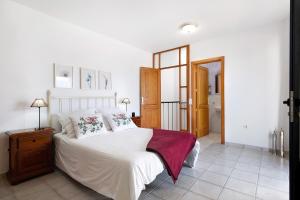 Schlafzimmer mit einem Bett mit weißer Bettwäsche und Kissen in der Unterkunft Apartamento Cabo in Caleta de Sebo