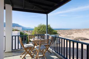a table and chairs on a balcony with a view of the beach at Apartamento Cabo in Caleta de Sebo